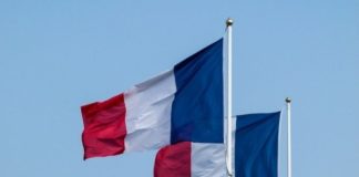 Des drapeaux de France devant un bâtiment public.